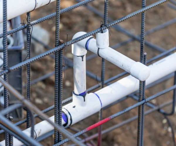 Newly Installed PVC Plumbing Pipes and Steel Rebar Configuration At Construction Site