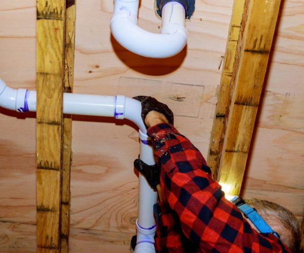 Plumber putting glue on a pvc pipe