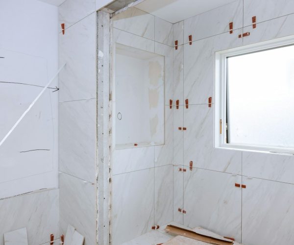 Work laying tile before applying tiles on bathroom tile.